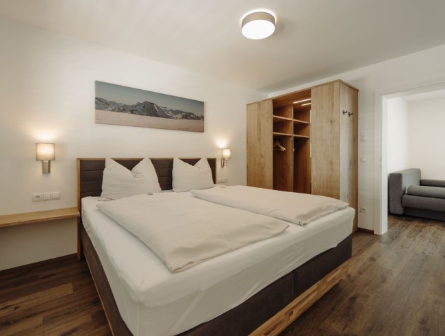 Schlafzimmer mit Doppelbett und Blick ins Badezimmer