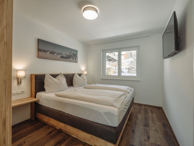 Schlafzimmer mit Doppelbett und Flat-TV